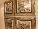 quatre tableaux encadrés accrochés au mur dans un couloir