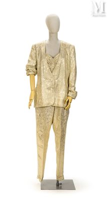 mannequin vêtu d'un costume doré, posé sur un socle métallique