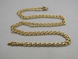 a close up of a gold chain on a gray surface