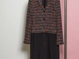 the coat is hanging on a hanger in front of a pink wall