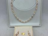 une boîte blanche contenant un collier et une paire de perles
