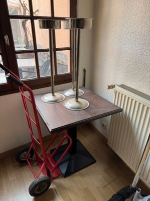 a small table with a red hand truck next to it