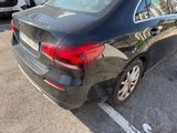a black car parked in a parking lot next to other cars