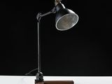 a close up of a desk lamp on a wooden stand