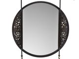 a round mirror with a tassel hanging on the side of it