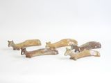 five small figurines of different shapes on a white surface