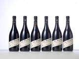 six bottles of wine lined up in a row on a table