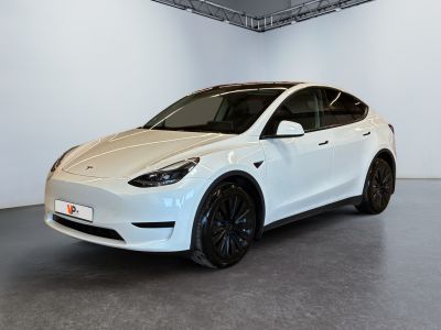 a white tesla model y parked in a white room