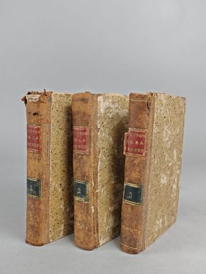 two old books sitting on top of each other on a table