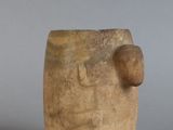 un petit vase marron surmonté d'une boule