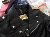 a pile of clothes and a jacket on a bed