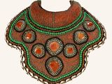 an image of a necklace with beads and stones on a white background