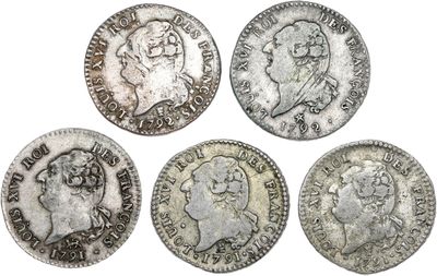 quatre pièces d'argent de tailles et de formes différentes sur un fond blanc