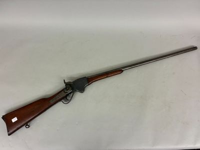 a rifle with a wooden barrel and a metal handle on a white surface