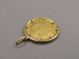 a close up of a gold coin on a silver surface