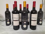 six bottles of red wine are lined up on a table