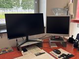 a desk with two computer monitors and a phone on it