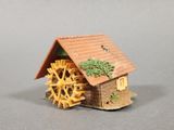 a small wooden house with a water wheel in front of it