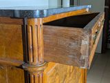 a wooden cabinet with a marble top in a kitchen