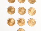gold coins arranged in the shape of a heart on a white surface