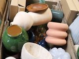 une boîte remplie de vases de toutes sortes posée sur une table