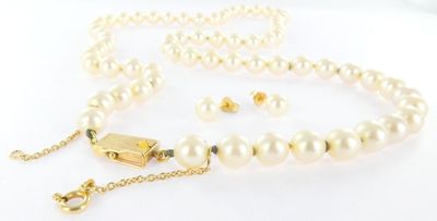a close up of a white pearl necklace with a gold clasp