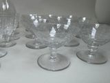 six wine glasses and a pitcher on a table
