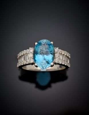 a close up of a ring with a blue topaz stone surrounded by white diamonds