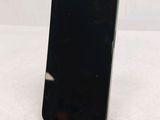 a black cell phone sitting on a stand on a table