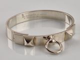 silver bracelet with a metal ring and a metal ring on a white surface