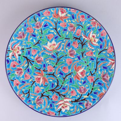 a blue and pink plate with a floral design on it