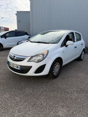 une Opel blanche garée sur un parking à côté d'un immeuble