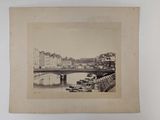 an old photo of a bridge over a river with boats