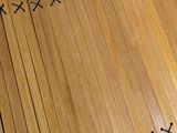 a close up of a piece of wood with black stitching on it