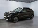 un SUV noir garé dans une grande pièce aux murs blancs
