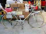 un homme debout à côté d'un vélo garé devant des cartons