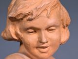 a small statue of a young girl holding a flower