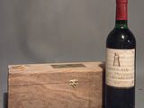 une bouteille de vin posée à côté d'une caisse en bois