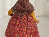 doll dressed in a red dress with a shawl on her head and a scarf on her head