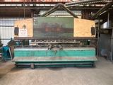 une photo d'une grande machine dans un entrepôt, sur laquelle est apposée une pancarte