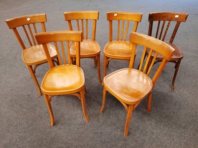 six wooden chairs are arranged in a circle on the floor