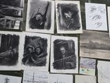 several black and white drawings of people and animals on a table