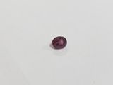 a purple sapphire stone on a white surface