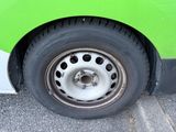a close up of a tire on a green bus