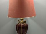 une lampe posée sur une table, avec un abat-jour rose