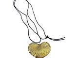 a close up of a gold heart pendant on a black cord