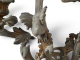 two birds that are sitting on a branch next to a candelier