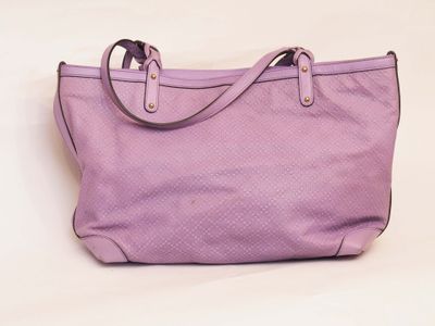 purple handbag on a white surface with a white background