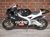 a black and white motorcycle parked in front of a brick wall