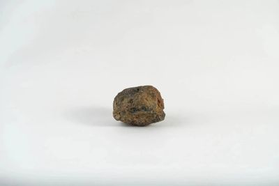 a small rock that is sitting on a white surface